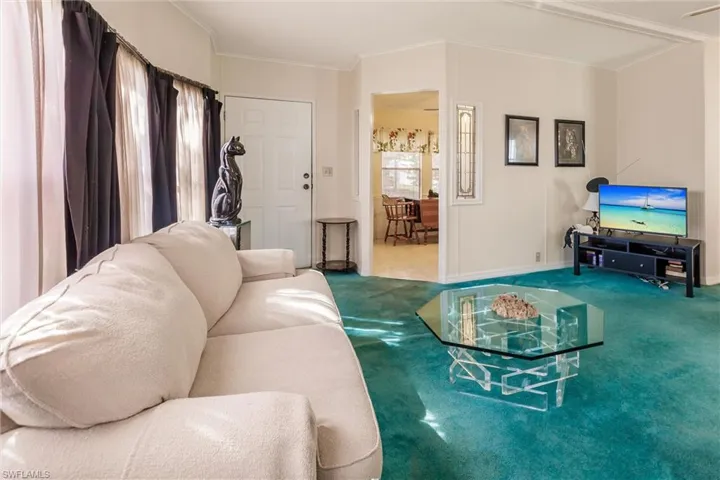 Living room with ornamental molding and carpet floors