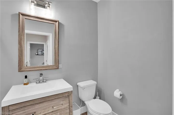 Half bathroom featuring vanity and toilet