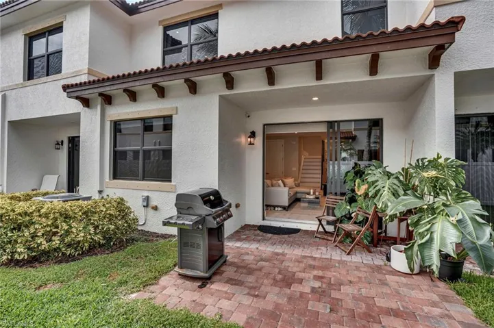 Entrance to property featuring stucco siding, a tiled roof, and a patio
