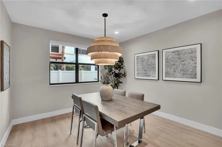 Dining room with light wood finished floors and recessed lighting