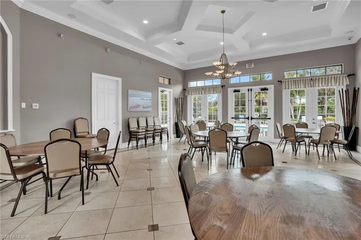 Dining area featuring a towering ceiling, crown molding, light tile patterned flooring, a chandelier, and beam ceiling