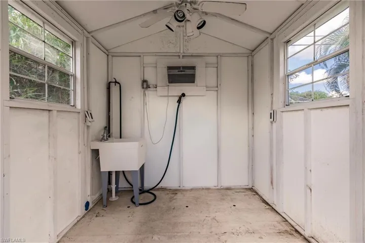 Basement with ceiling fan and a wall mounted air conditioner
