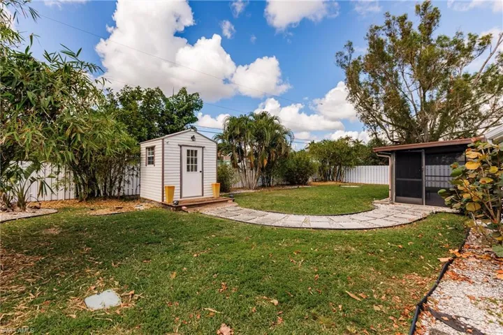View of yard featuring a storage shed and a sunroom
