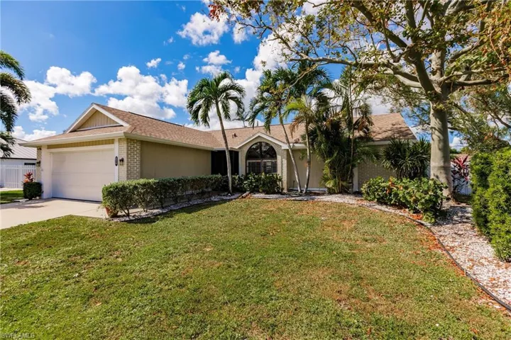 Ranch-style home with a front yard and a garage