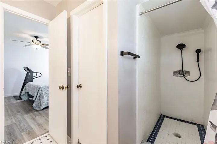 Bathroom with walk in shower, hardwood / wood-style flooring, and ceiling fan