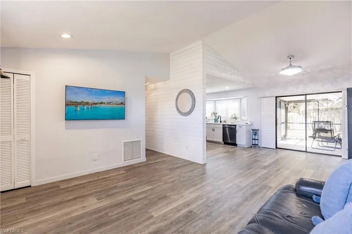 Living room featuring wood-type flooring and lofted ceiling