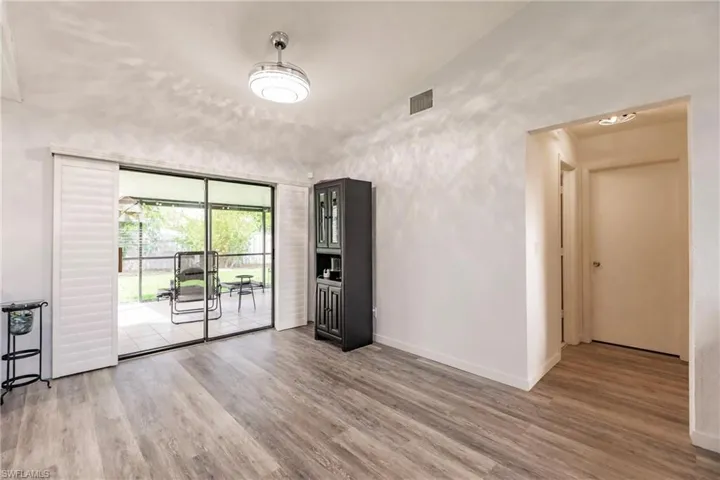 Empty room featuring lofted ceiling and light hardwood / wood-style floors