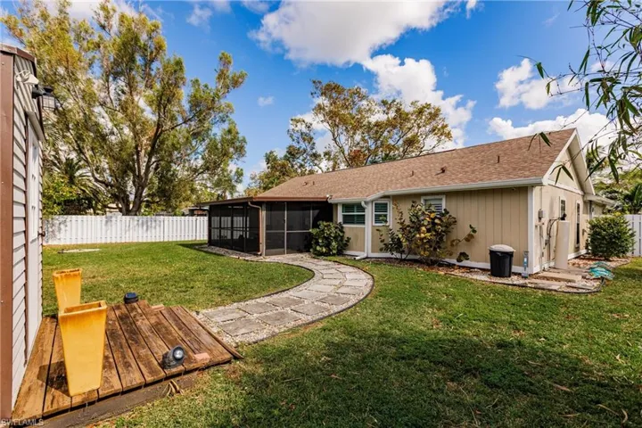 Rear view of house featuring a lawn and a sunroom