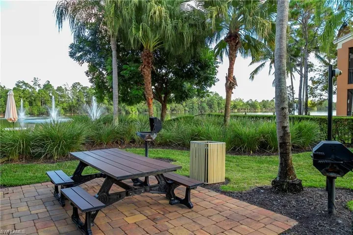 View of property's community featuring a patio area, a water view, and outdoor dining area