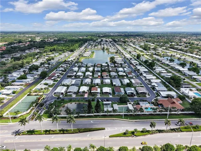 Expansive community featuring multiple residential properties, a central lake, and mature landscaping