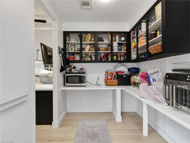 Dedicated pantry space featuring light wood-finish flooring