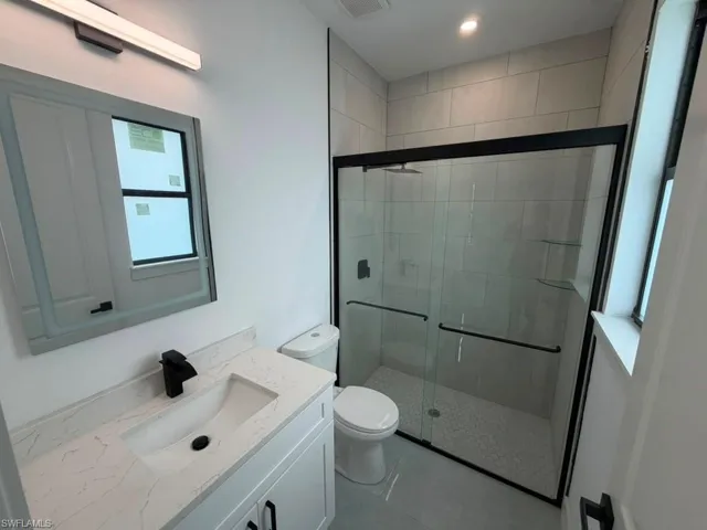 Modern bathroom featuring a white vanity with a quartz-finish countertop and an undermount sink
