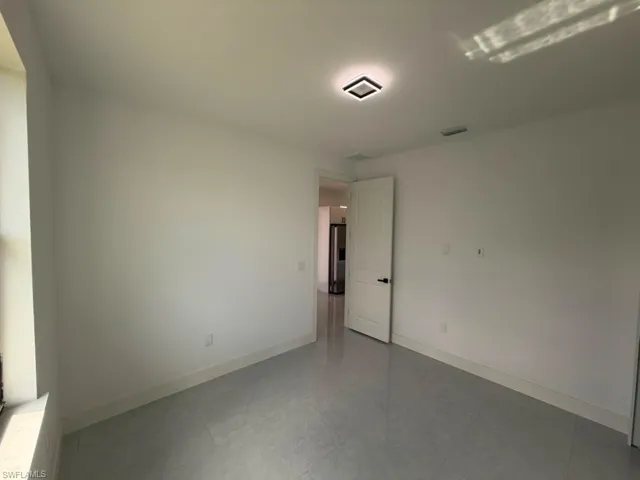 Bright room featuring light grey tile flooring, white baseboards, and a modern flush-mount ceiling light