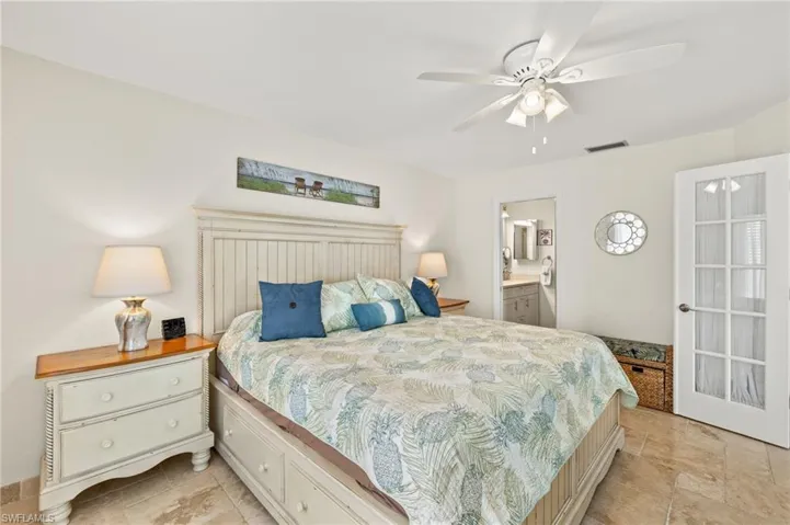 Bedroom with a ceiling fan, visible vents, and connected bathroom