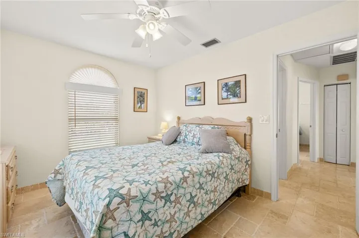 Bedroom featuring baseboards, visible vents, and stone tile floors