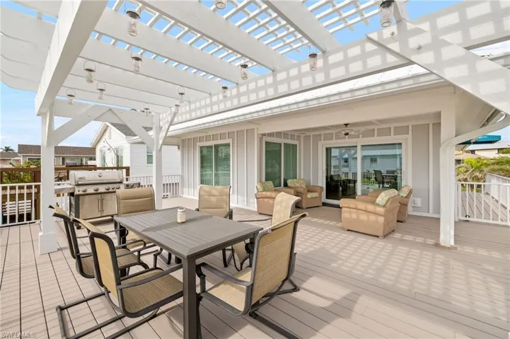 Deck featuring area for grilling, ceiling fan, an outdoor hangout area, a pergola, and outdoor dining space