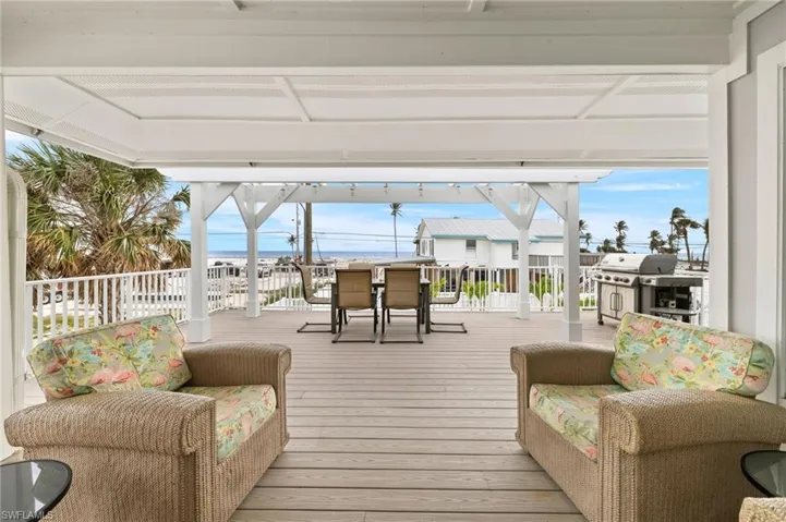 Wooden terrace featuring outdoor dining area and grilling area