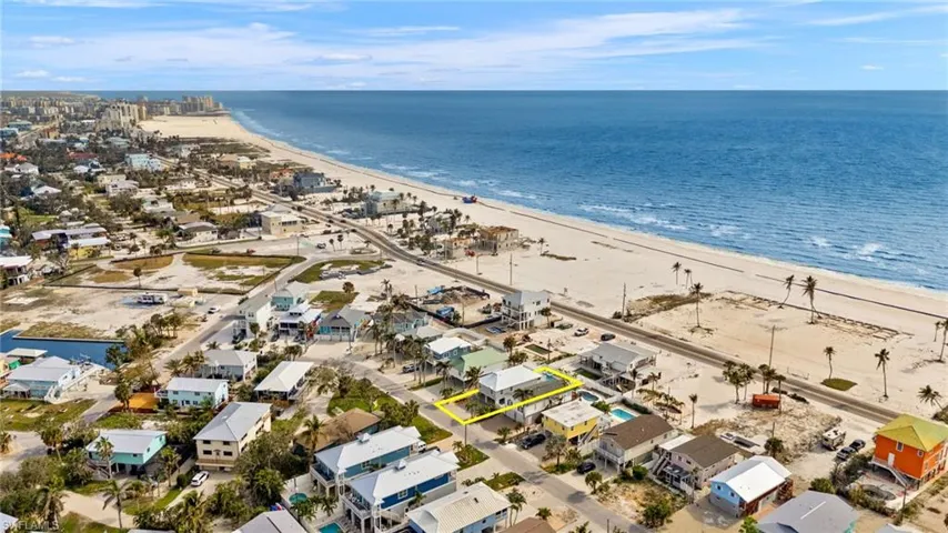 Virtually Enhanced Birds eye view of property with a water view and a beach view