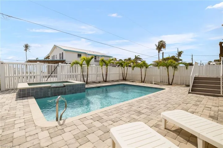 View of pool with a fenced backyard, a pool with connected hot tub, and a patio