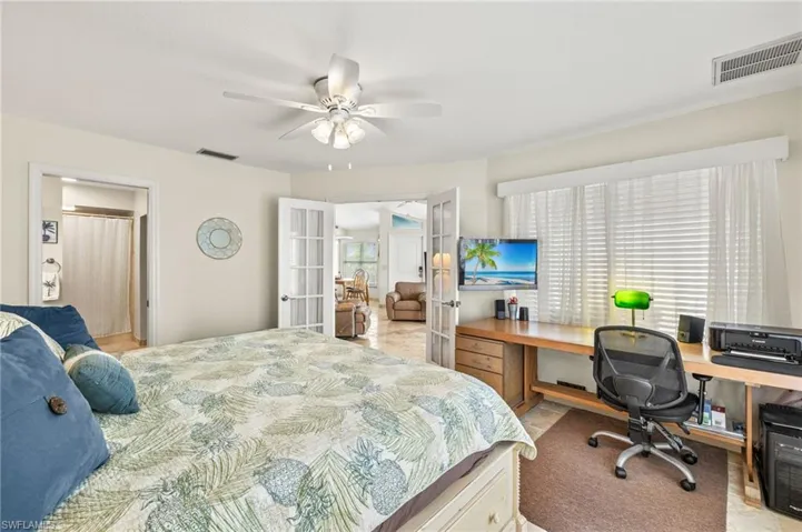 Bedroom with ceiling fan, french doors, and visible vents