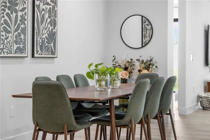 Dining area featuring a rectangular wood-finish table, upholstered chairs, and wood-finish flooring