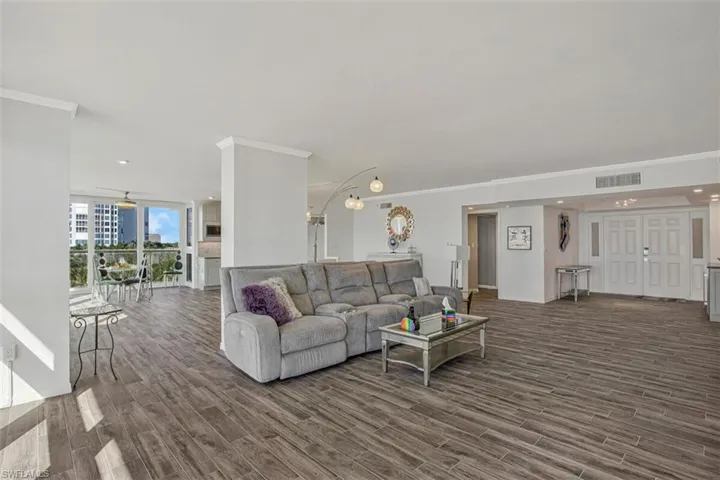 Living room featuring crown molding, dark wood-style floors, a wall of windows, and recessed lighting