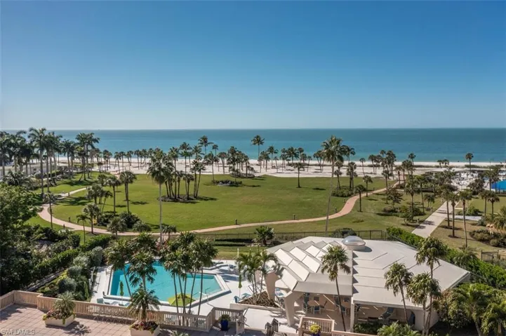 Aerial view of a pool area and a large body of water
