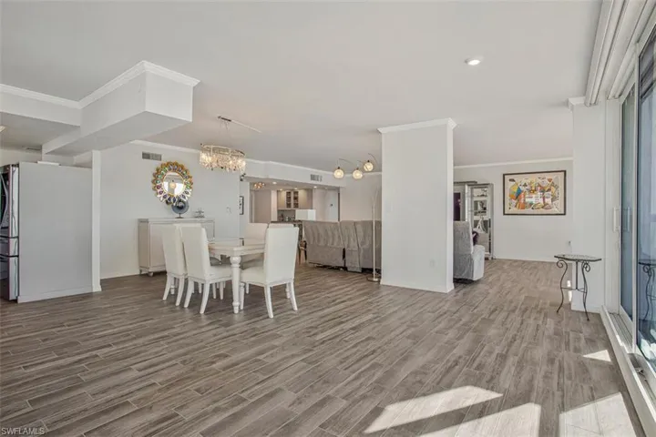Dining space featuring wood finish floors, a chandelier, and ornamental molding