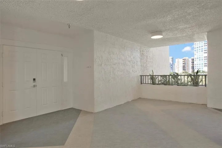 Carpeted spare room with a textured ceiling, a textured wall, and a city view