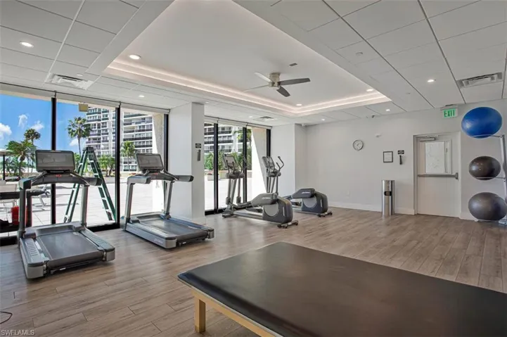 Exercise room featuring expansive windows, ceiling fan, and recessed lighting