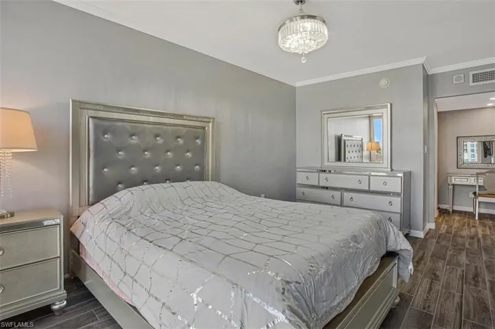 Bedroom featuring wood finish floors and crown molding