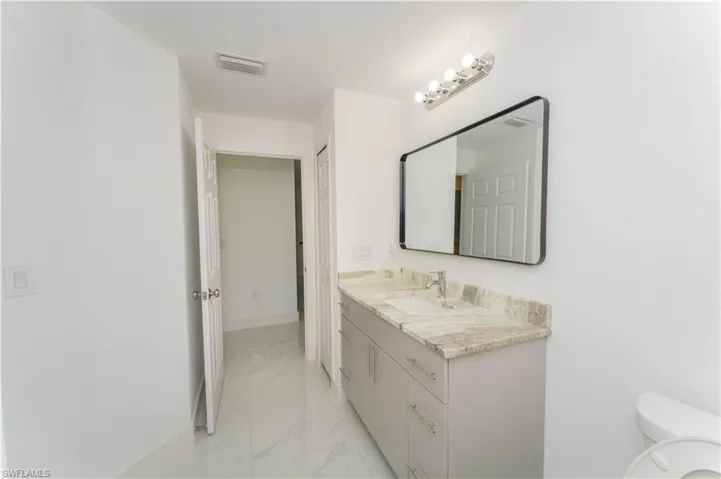 Bathroom featuring marble finish floors and vanity