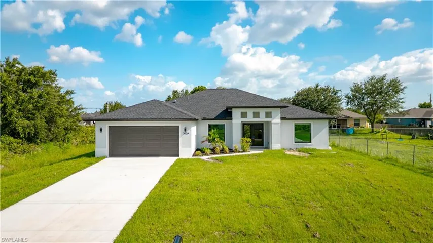 View of front of home featuring stucco siding, a garage, driveway, and roof with shingles