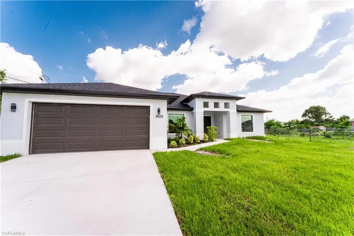 Prairie-style house featuring stucco siding, driveway, and an attached garage