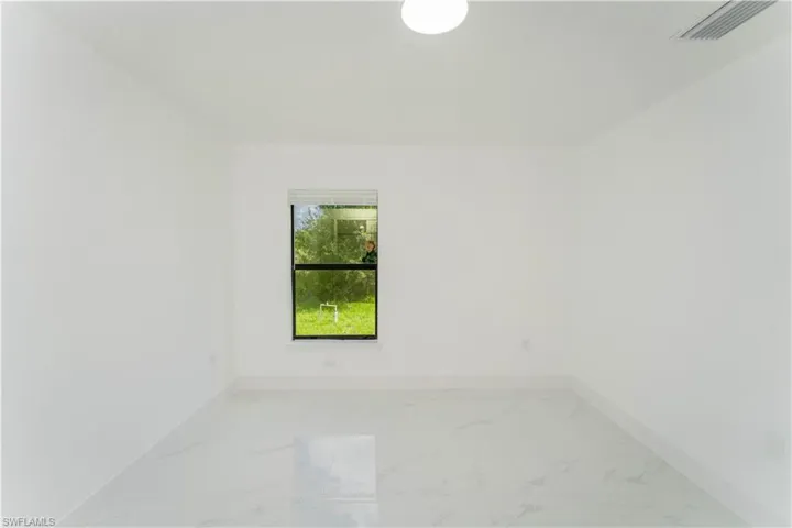 Spare room with baseboards and light marble finish floors