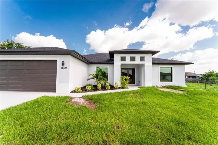 Prairie-style home featuring stucco siding, a garage, concrete driveway, and a shingled roof