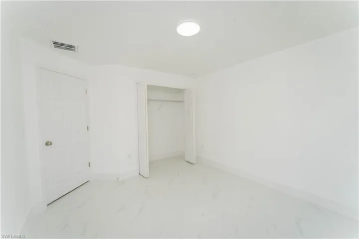 Unfurnished bedroom with light marble finish flooring and a closet