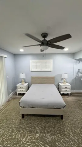 Bedroom featuring wood finished floors, baseboards, and a ceiling fan