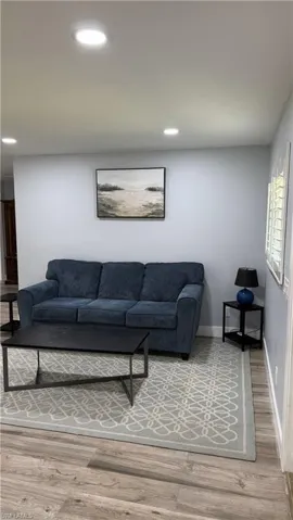 Living room featuring wood finished floors, baseboards, and recessed lighting