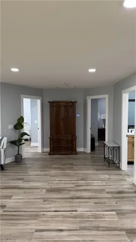 Living area with light wood finished floors, recessed lighting, and baseboards
