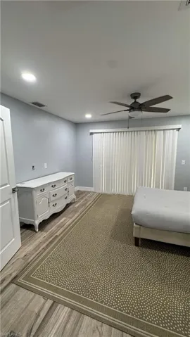 Bedroom with wood finished floors, ceiling fan, and baseboards