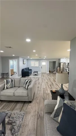 Living area featuring light wood-type flooring, recessed lighting, healthy amount of natural light, and baseboards