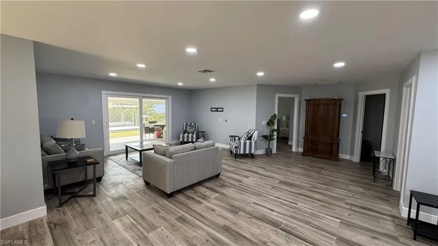 Living room featuring recessed lighting, light wood-style floors, and baseboards