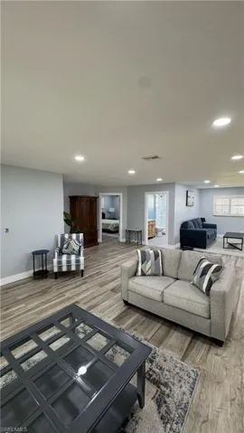 Living area with recessed lighting, baseboards, and wood finished floors