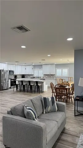 Living room with recessed lighting and light wood-style flooring
