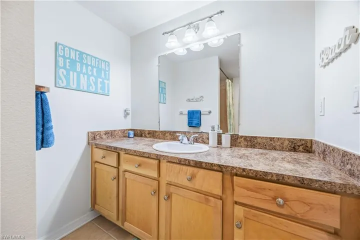 Bathroom with vanity, a shower with shower curtain, and light tile patterned floors
