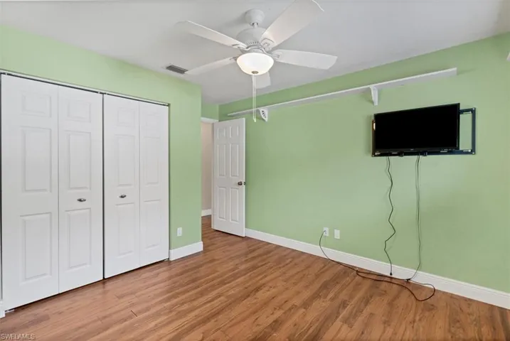 Unfurnished bedroom featuring a closet, hardwood / wood-style floors, and ceiling fan