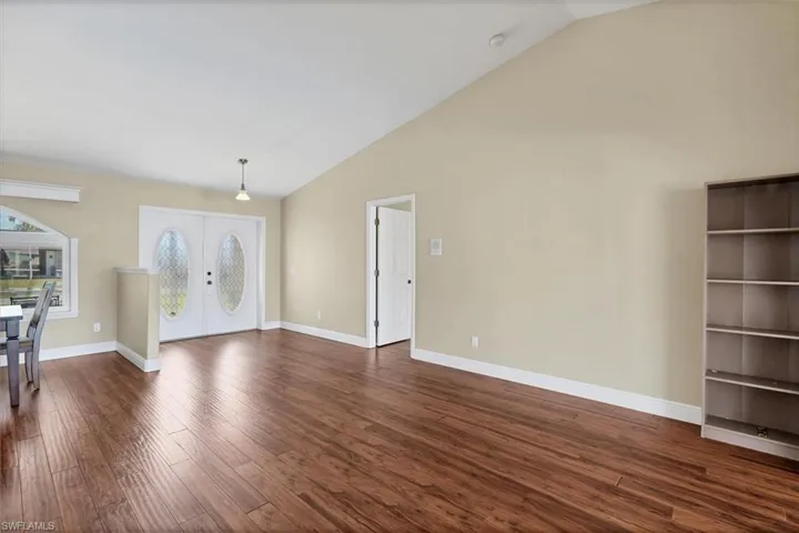 Foyer entrance with dark wood-type flooring, lofted ceiling, and french doors