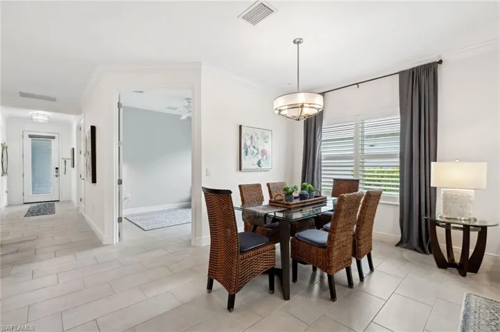 Tiled dining room featuring ornamental molding
