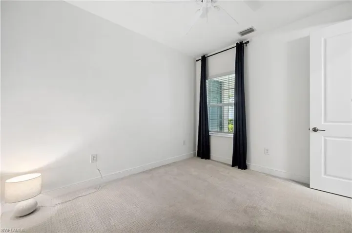 Carpeted spare room with ceiling fan